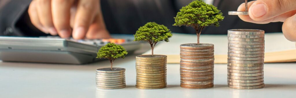 Stack of coins with miniature trees growing out of the top