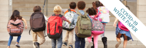 children with backpacks walking into a school